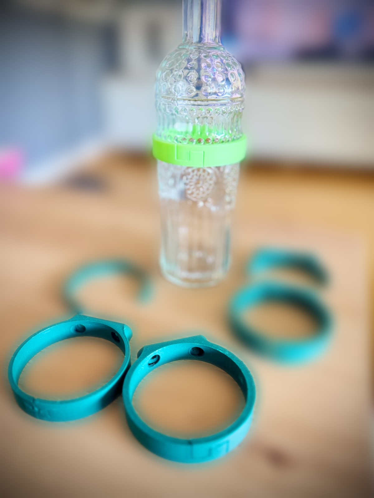 Türkise Ringe, mit denen eine Glasflasche an der Wand hängt